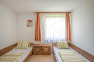 ザンクト・カンツィアン・アム・クロッパイナー・ゼーにあるFerienwohnungen Eckwirt Region: Klopeinersee-Turnerseeのベッド2台と窓が備わる小さな客室です。