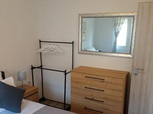 a bedroom with a dresser and a mirror next to a bed at Frka-Petešić in Sali