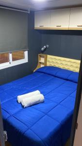 Una cama azul con sábanas azules y una toalla blanca. en Relax in pasito blanco camping house, en Maspalomas