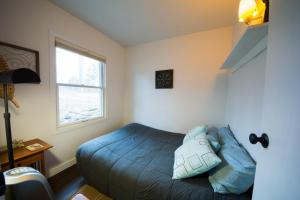a bedroom with a bed with blue sheets and a window at Lake House in Nashville