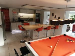 a kitchen with a ping pong table in the middle of a kitchen at Villa DO MI SI LA DO RE in Labenne