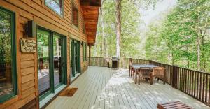 a deck with a table and chairs on a house at Paradise View Log Cabin in Nashville