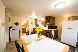 uma cozinha com uma mesa e um frigorífico branco em Daffodil Hill em Nashville
