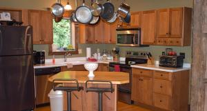 una cocina con armarios de madera y una mesa de madera con taburetes. en Natures Nest, en Nashville