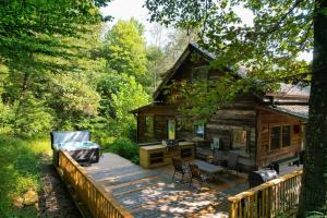 Cabaña de madera con terraza con sillas y mesa en Natures Nest, en Nashville