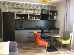 eine Küche mit einem Tisch, 2 Stühlen und einem Tisch in der Unterkunft Dream Apartament in Morschyn