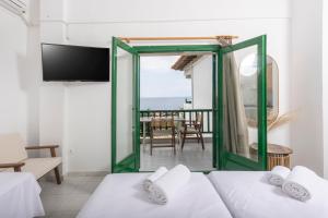 a room with two beds and a view of the ocean at D&G Apartments in Agia Paraskevi