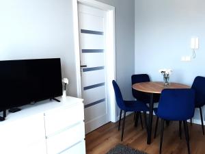 a dining room with a table and blue chairs at Apartament Wawa in Warsaw
