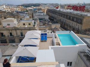 a woman standing on the roof of a building with umbrellas at St Gaetan Accomodation 6B in Hamrun