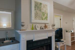 a living room with a fireplace and a television at 1135 Summerwind Cottage in Seabrook Island