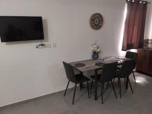 a dining room table with chairs and a television on a wall at St Gaetan Accomodation 6B in Hamrun