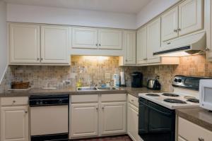 a kitchen with white cabinets and a stove top oven at 1135 Summerwind Cottage in Seabrook Island