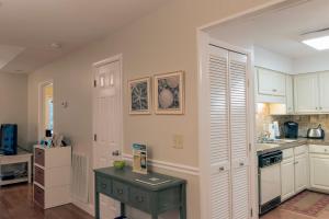a kitchen with white cabinets and a table in it at 1135 Summerwind Cottage in Seabrook Island +26 photos