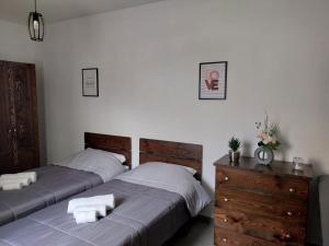 a bedroom with two beds and a dresser with towels at St Gaetan Accomodation 6B in Hamrun