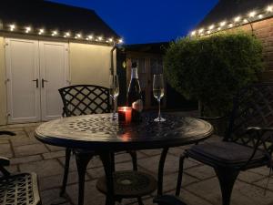 a table with two glasses of wine and a candle at Cream Cottage Annex in Poole