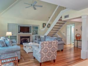 a living room with a couch and a staircase at 779 Spinnaker Beach House in Seabrook Island +23 photos