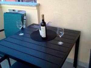 una bottiglia di vino seduta su un tavolo con due bicchieri di Frka-Petešić a Sali (Sale)