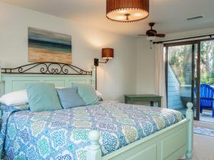 a bedroom with a bed with a blue and white comforter at 779 Spinnaker Beach House in Seabrook Island