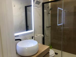 ein Badezimmer mit einem weißen Waschbecken und einer Dusche in der Unterkunft El Apartamento de Cristian 3 in Benidorm