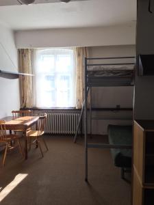 a room with a bunk bed and a table and a desk at Hostel Pestalozza in Špindlerův Mlýn