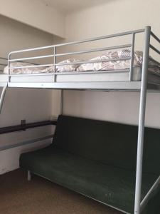 a bedroom with two bunk beds and a chair at Hostel Pestalozza in Špindlerův Mlýn