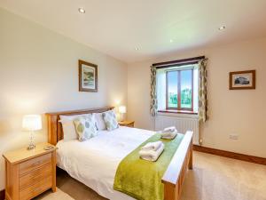 a bedroom with a bed and a window at Warth Barn - Uk44211 in Ingleton