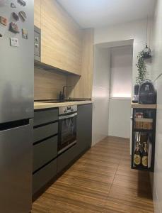 Una cocina con refrigerador de acero inoxidable y pisos de madera. en The Clock Tower Apartment, en Jaén 12 fotos más