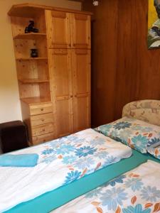 1 dormitorio con 1 cama y armario de madera en Zsiga Apartmanház en Balatonszabadi