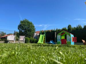 a playground with a play set in the grass at Domek na Wiejskiej in Zator