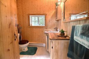 a wooden bathroom with a toilet and a sink at Le Chouette Chalet in La Malbaie +31 photos