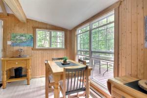 a dining room with a table and a desk at Le Chouette Chalet in La Malbaie