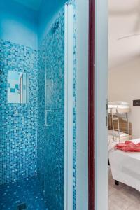 y baño con ducha de azulejos azules. en B&B Villa Madana en Rímini