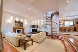 Anthemis Luxury Villa في كاليمنوس: غرفة معيشة مع درج حلزوني وغرفة معيشة
