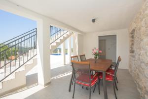 a dining room with a table and chairs and a balcony at La casa Gidora in Šibenik