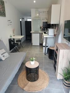 a kitchen and living room with a table in a room at Studio cocooning avec jardin in Montpellier