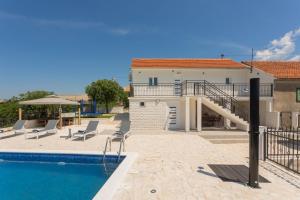 a house with a swimming pool next to a building at La casa Gidora in Šibenik