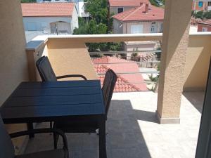a blue table and chairs on a balcony at Frka Petešić in Sali +1 photo