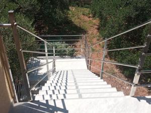 un conjunto de escaleras con barandilla metálica en Frka Petešić en Sali