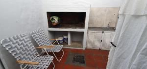 two chairs in a room with a sink and a kitchen at Manantial Departamentos in Gualeguay