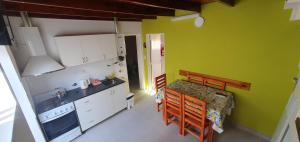 eine Küche mit einem Tisch und eine Küche mit grünen Wänden in der Unterkunft Manantial Departamentos in Gualeguay