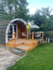 a gazebo with a table and chairs on a deck at Railway Pod, Castlewellan in Castlewellan