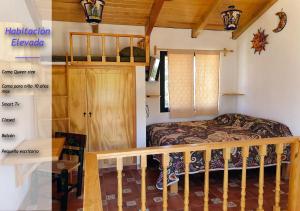 1 dormitorio con 1 cama y escalera de madera en Mini Casa Colibri en Mazamitla