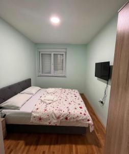 Un dormitorio con una cama y un televisor. en Stan na dan Milena, en Trebinje 6 fotos más