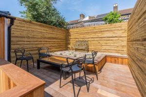 a patio with a wooden fence and a table and chairs at Delightful Blue Shells Cottage - 2bedrooms -Garden - 5mins beach - 1min Shell Grotto in Kent