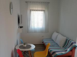een kleine kamer met een bank, een tafel en een raam bij Frka Petešić in Sali