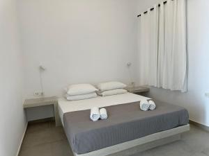 a bedroom with a bed with towels on it at Niabelo Villa in Kamari