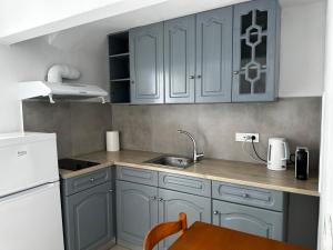 a kitchen with blue cabinets and a sink and a table at Niabelo Villa in Kamari