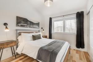 a white bedroom with a bed and a window at Le Memph Chouette spacious comfortable condo cottage eco responsible 3 bedrooms private garage - hot tub & pool Memphrémagog Lake in Magog-Orford +19 photos