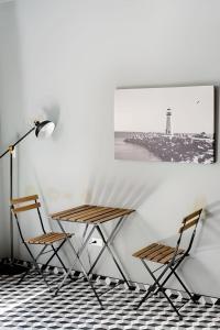 a table and chairs in a room with a lighthouse at The Studios 22800 in Ensenada