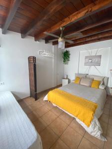 1 dormitorio con 1 cama con manta amarilla en HAPPY HOUSE NANE en Playa Honda